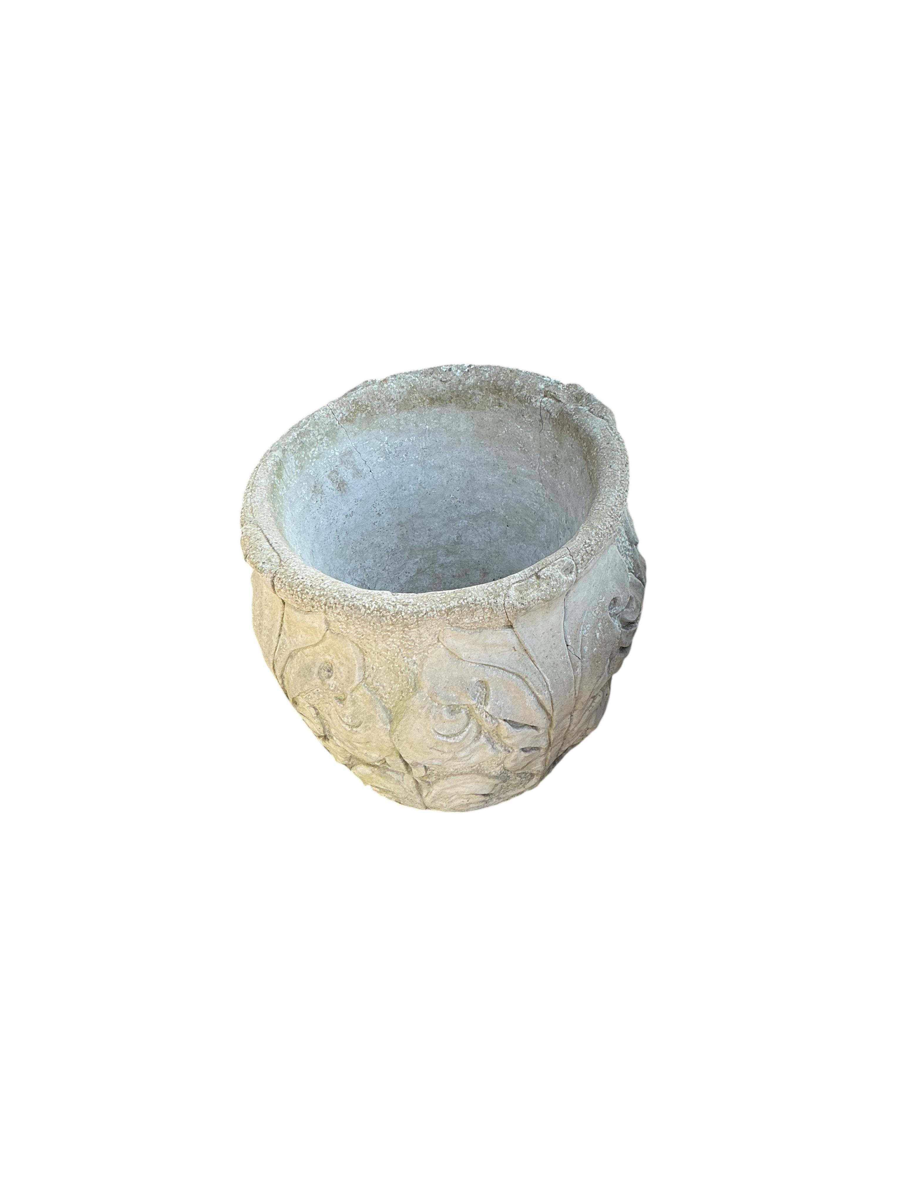 An oval reconstituted stone garden planter, width 80cm, height 30cm together with a circular stone planter